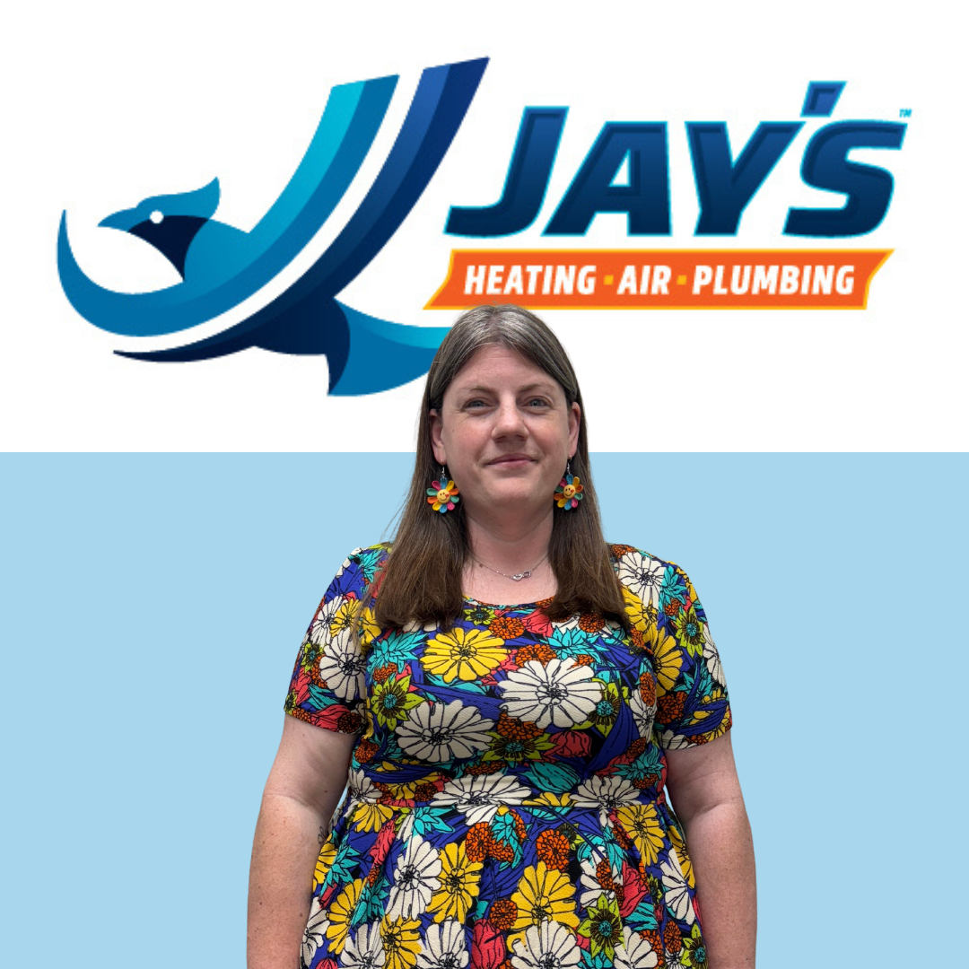 A woman in a colorful floral dress stands in front of a wall featuring the Jay’s Heating, Air, Plumbing logo, home to 5-Star Technicians.