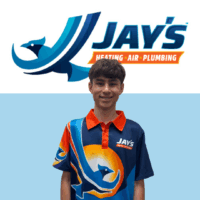 A young man wearing a branded Jay’s Heating, Air, Plumbing shirt stands in front of the company logo and name on a light blue background, representing the team’s 5-Star Technicians and commitment to top-quality service.